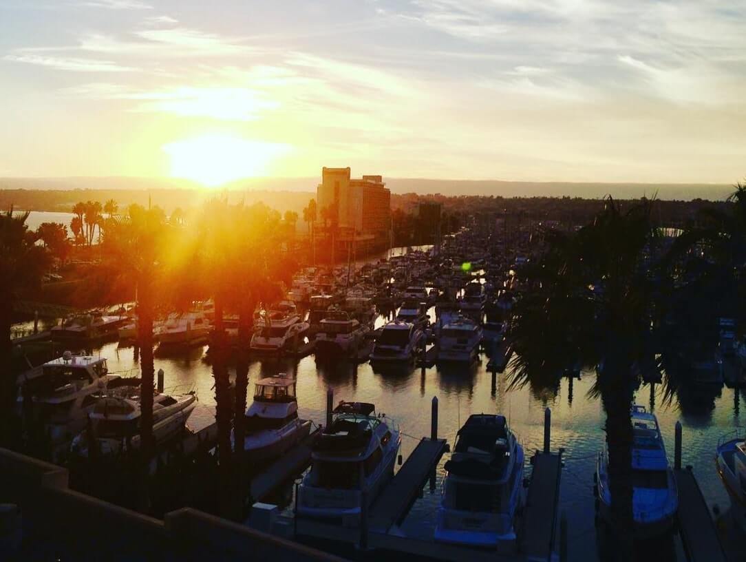 The sun shining over a San Diego harbor.